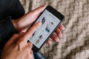 Eine Frau surft auf ihrem iPhone in einem Online-Shop