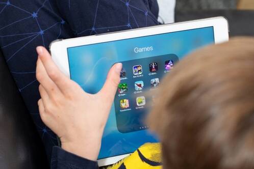 iPad als Spielgerät einsetzen Ein Junge verwendet sein iPad fürs mobile Gaming