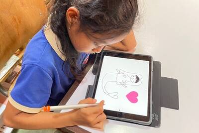 Ein Mädchen zeichnet eine Meerjungfrau auf dem iPad