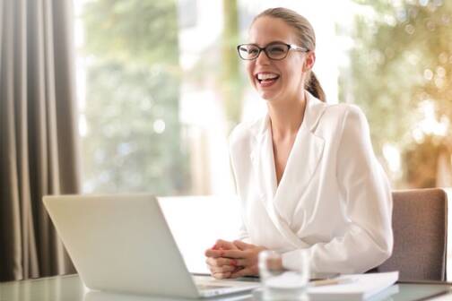 Frau in weisser Bluse arbeitet mit MacBook