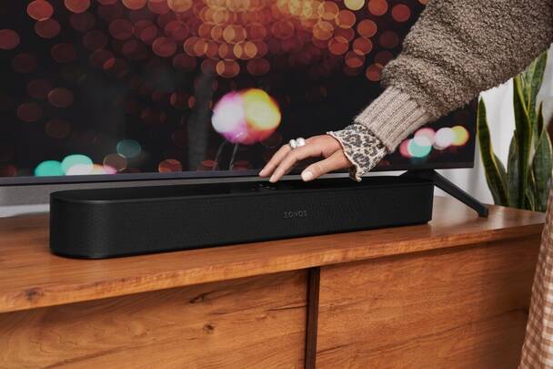 Frau bedient Touch-Feld der Sonos Beam (2. Gen) Soundbar