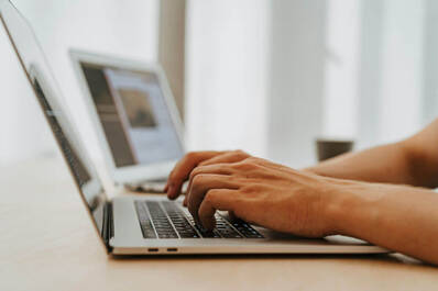 Zwei Männerhände auf Tastatur von MacBook