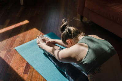 Frau beim Stretching auf Yogamatte